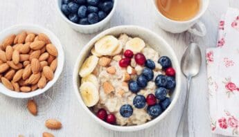 7 Delicious Mediterranean Diet Breakfast Menu Options to Energize Your Mornings 10 Almond oatmeal bowl with blueberries, bananas, and red currants on a white wooden table, healthy breakfast, nutritious food, fitness meal, Start to Fit website.