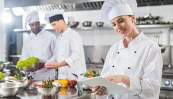 Culinary chefs in a professional kitchen preparing fresh vegetables and ingredients for healthy meals, demonstrating expert cooking skills and dedication to nutritious cuisine.