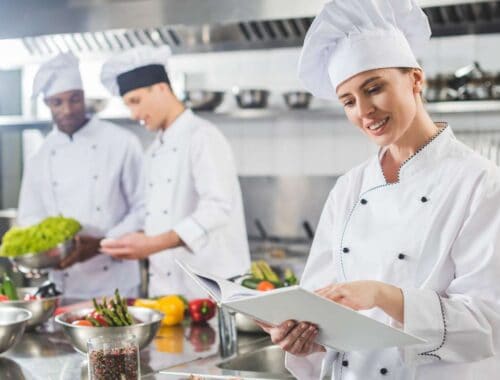 Culinary chefs in a professional kitchen preparing fresh vegetables and ingredients for healthy meals, demonstrating expert cooking skills and dedication to nutritious cuisine.