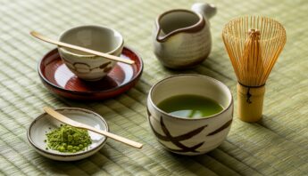 Elegant Matcha Tea Sets for Authentic Japanese Brewing 19 Green tea and matcha powder with traditional Japanese tea utensils on a bamboo mat, emphasizing healthy beverage choices for wellness.