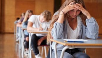 Stressful school exam scenario with focused students taking a test in classroom.