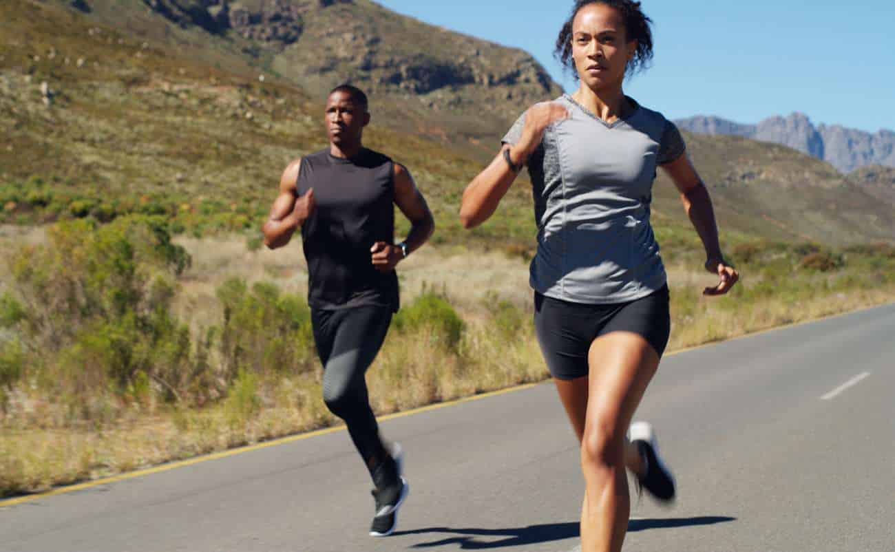 Running outdoors on scenic mountain road for fitness and health.