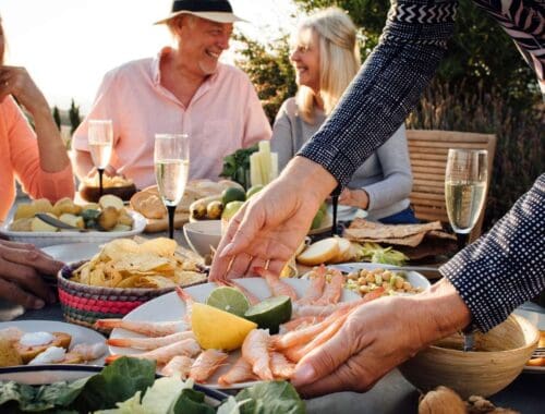 Fresh seafood and healthy food options shared during an outdoor gathering with friends, promoting balanced eating and social wellness.