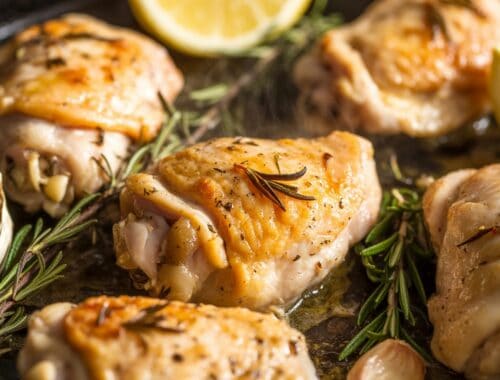 Succulent roasted chicken thighs with herbs and lemon slices for healthy eating and nutritious meal prep.