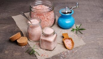 What Is the Pink Salt Trick for Weight Loss? Benefits & Recipe 8 Pink Himalayan salt in jars and a salt grinder on a wooden surface for health and wellness.