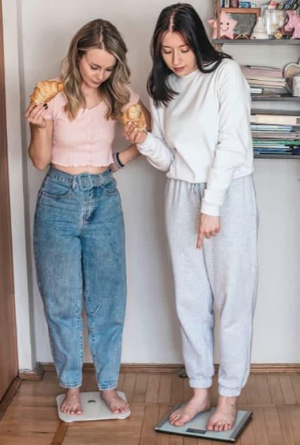 Girls measure weight on machine with food for Weight loss