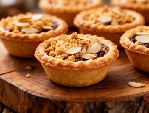 Delicious mini almond tartlets topped with sliced almonds and a crumbly crust, perfect for dessert or special occasions.