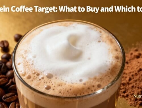 A close-up of a frothy protein coffee in a glass cup, surrounded by coffee beans and a mound of cocoa powder on a golden background.