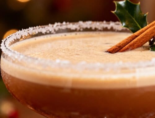 Delicious holiday-themed cocktail with cinnamon sticks and holly garnish, ideal for winter festivities and emphasizing balanced, festive drinks.