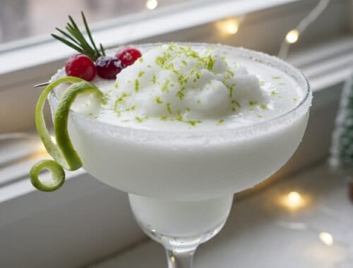 Delicious holiday-themed white cocktail garnished with red berries, lime peel, and whipped cream, perfect for celebrating health and wellness during festive seasons.