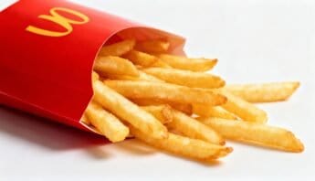 Delicious, crispy French fries spilling out of a red fast-food container, perfect for snacks or meals, emphasizing fast food and casual dining.