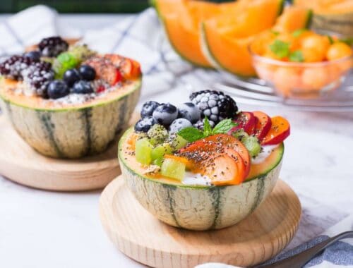 Fresh fruit salad served in watermelon bowls with assorted berries, grapes, and sliced melons, providing a colorful, healthy, and delicious option for a nutritious snack or dessert.