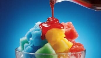 Sugar Free Snow Cone Syrup 12 Brightly colored snow cones with syrup being poured, fresh and delicious summer treats. Perfect for hot weather, featuring vibrant hues of blue, yellow, green, and red against a clear glass and blue background.