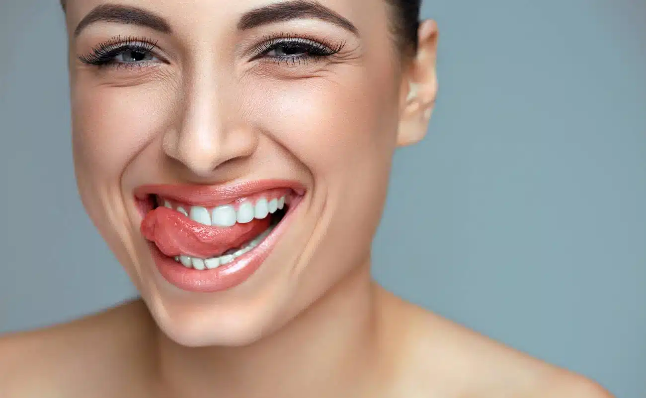 Bright smiling woman with tongue out, showcasing healthy teeth and a playful expression.